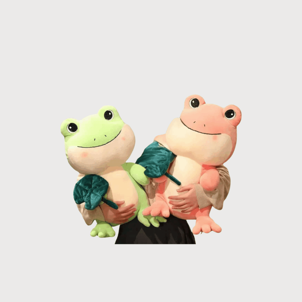 Doudou Grenouille Style Cartoon 25 cm : Deux doudous grenouilles, vert clair et pêche, tenant une feuille verte dans leurs bras.