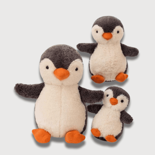 Doudou Pingouin Mignon pour Enfant : Trois doudous pingouins noirs et blancs avec des pieds orange, parfaits pour les enfants.