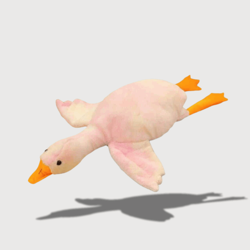 Doudou Canard Géant : Doudou canard jaune pastel en vol, avec des ailes et des pattes orange.