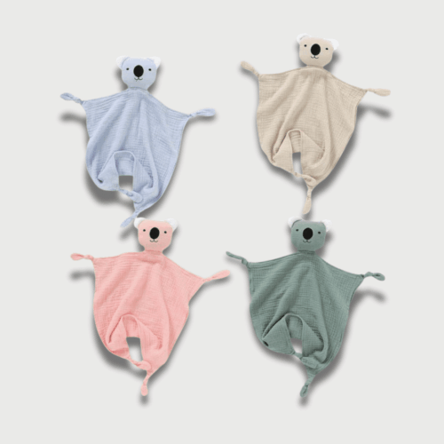 Doudou Plat Koala 30 cm disponible en quatre couleurs pastel (bleu, beige, rose et vert) avec un visage brodé et une texture moelleuse.