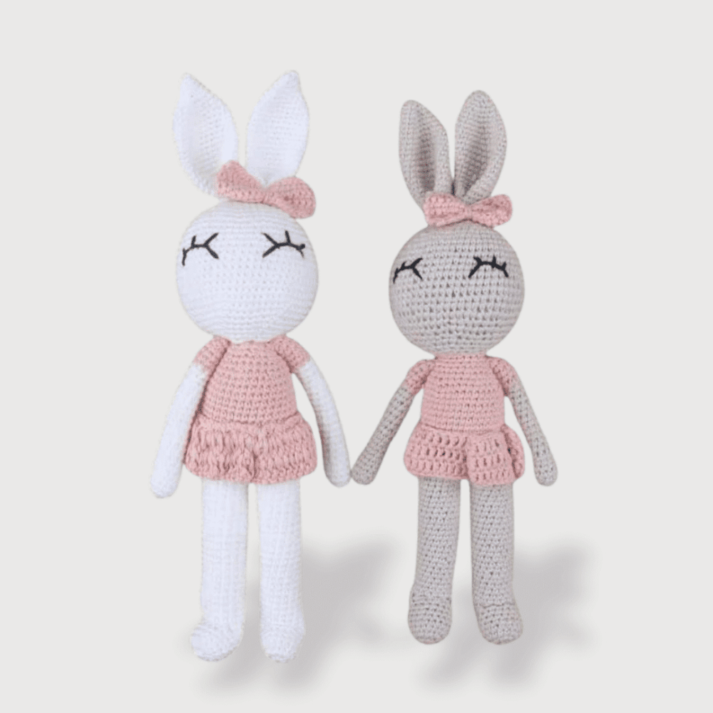 Doudou Crochet Lapin pour Fille 32 cm avec de longues oreilles, une robe rose et un joli nœud assorti.