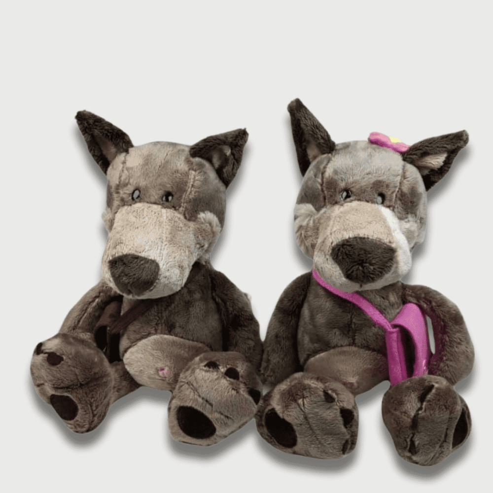 Doudou Loup Avec Sac Cachemire 25 cm, deux doudous loups assis dont un porte un sac rose et un nœud.