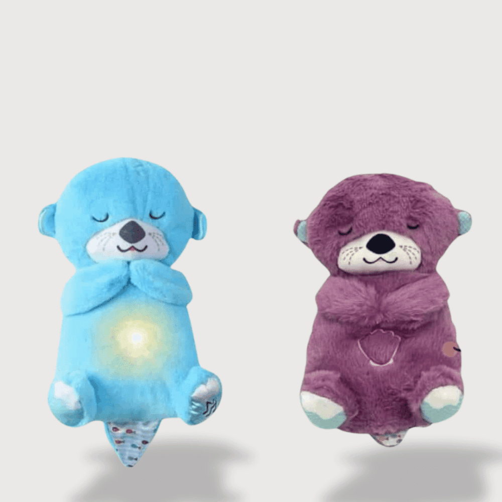 Doudou Bébé Loutre Respirant 30 cm , aux couleurs bleu et violet, avec une lumière apaisante sur le ventre.