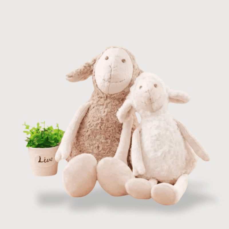 Doudou Mouton Unisexe 40 cm : Deux doudous moutons assis, un beige et un blanc, avec de longues jambes et un pot de plante à côté.