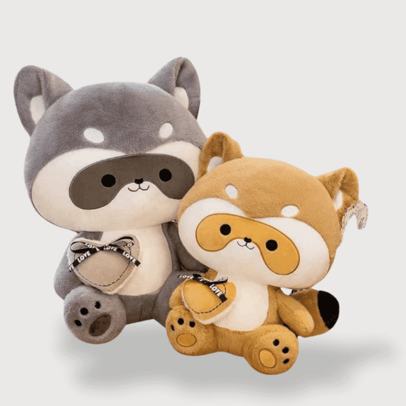 Doudou Raton Laveur Très Mignon, un raton laveur gris et un marron, chacun tenant un cœur ultra-doux dans ses pattes.