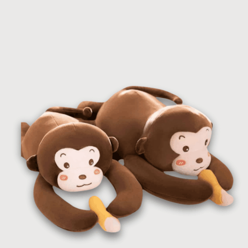 Doudou Singe à Bras Long , deux doudous singes marrons allongés tenant une banane dans leurs bras.