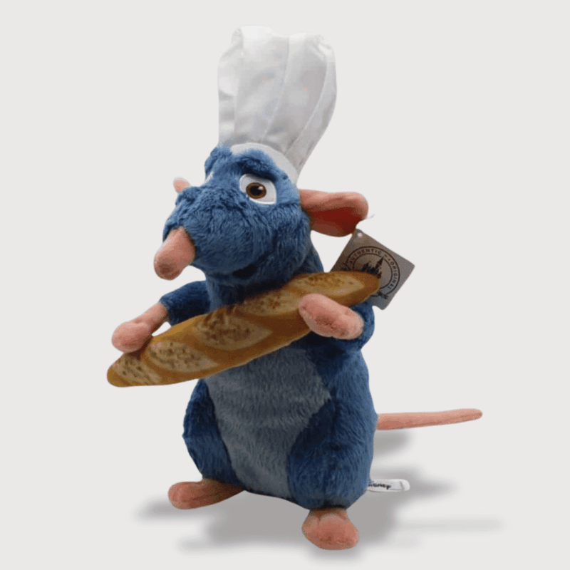 Doudou Souris Ratatouille 28 cm : Doudou souris bleu portant une toque de chef et tenant une baguette de pain.