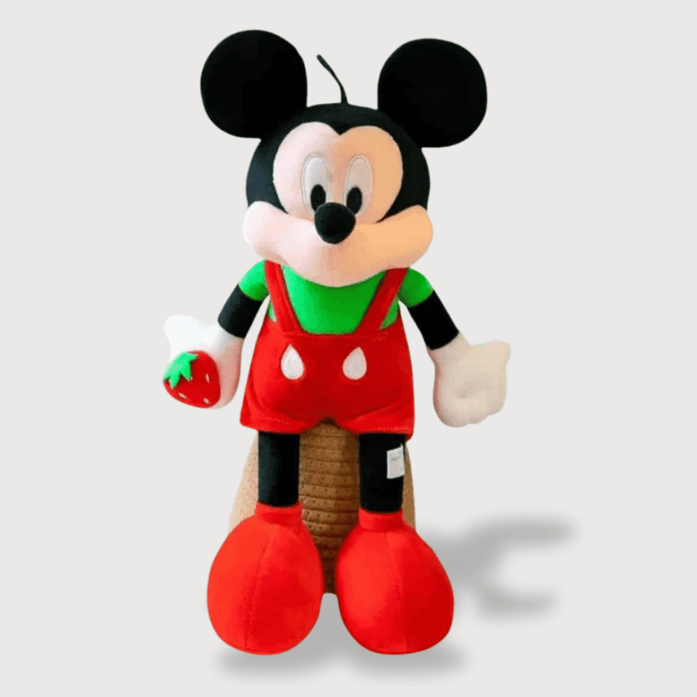 Doudou Mickey en Costume de Noël 40 cm : Un doudou Mickey en tenue de Noël, avec une salopette rouge et un pull vert, tenant une fraise.