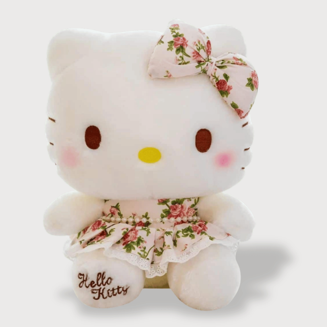 Doudou Kittie Petit et Adorable 1 Doudou Kittie Petit et Adorable : Un doudou Hello Kitty blanc avec une robe fleurie et un nœud assorti sur la tête.