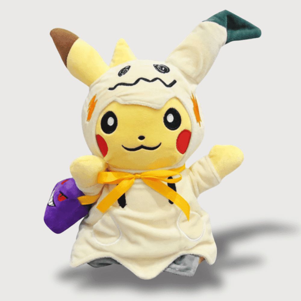 Doudou Pikachu Déguisé en Mimiqui : Un doudou Pikachu avec un costume de Mimiqui beige, un ruban orange et un sac violet.