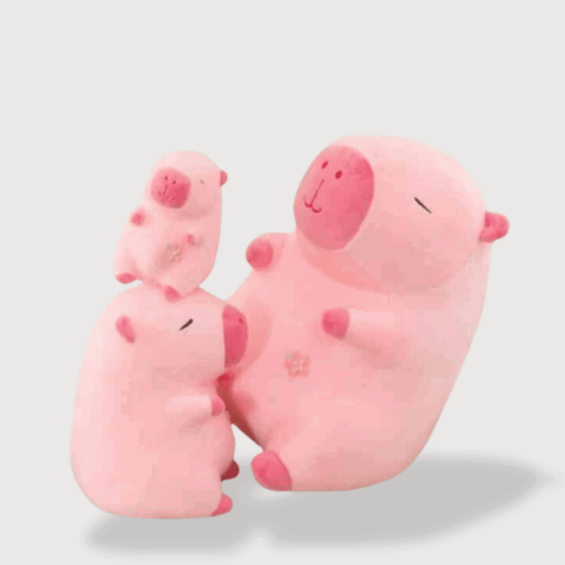 Doudou Rose Capybara composé de trois capybaras roses empilées, aux yeux fermés, joues rondes et texture moelleuse.