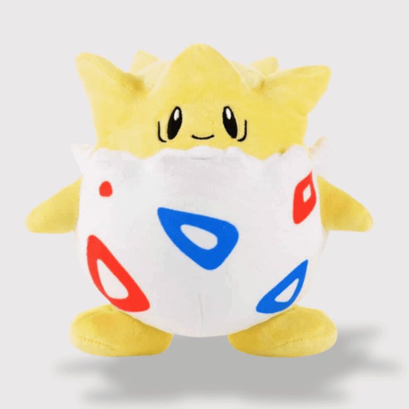 Doudou Pokemon Togepi : Un doudou Togepi jaune et blanc, sortant d’un œuf décoré de motifs rouges et bleus.