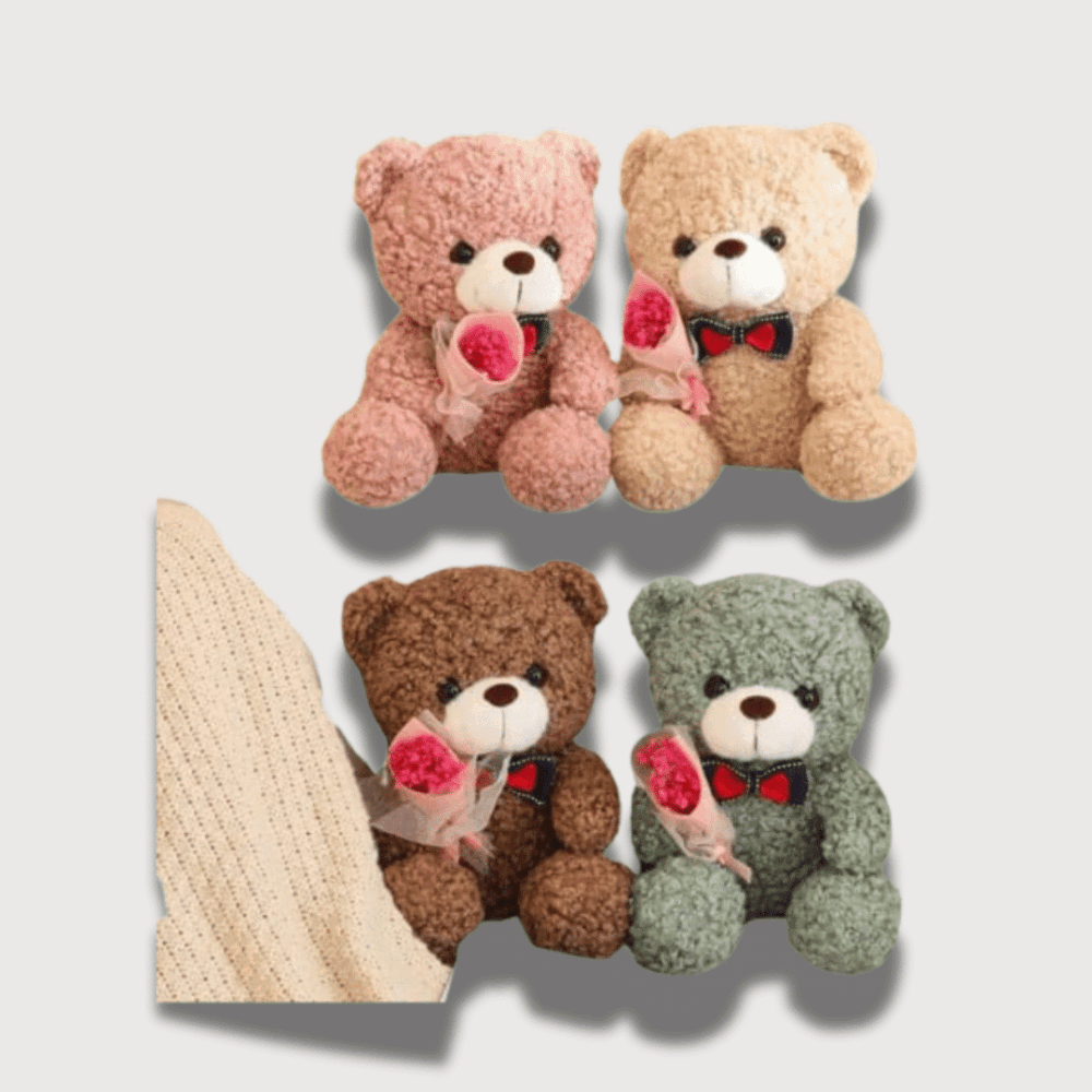 Doudou Petit Ours Ultra-Doux 25 cm en texture laineuse, avec un petit nœud papillon et une rose à la main, disponible en différentes couleurs : rose, beige, marron et vert.