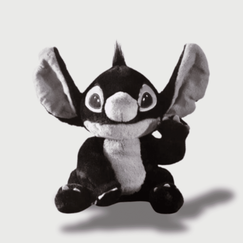 Doudou Stitch Noir 20 cm : Un doudou Stitch noir et blanc, avec des grandes oreilles grises.