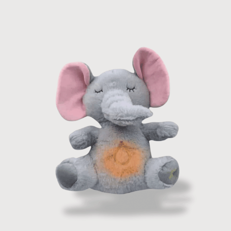 Doudou Éléphant Doux Respire aux grandes oreilles roses, avec une lumière douce et des yeux brodés fermés.