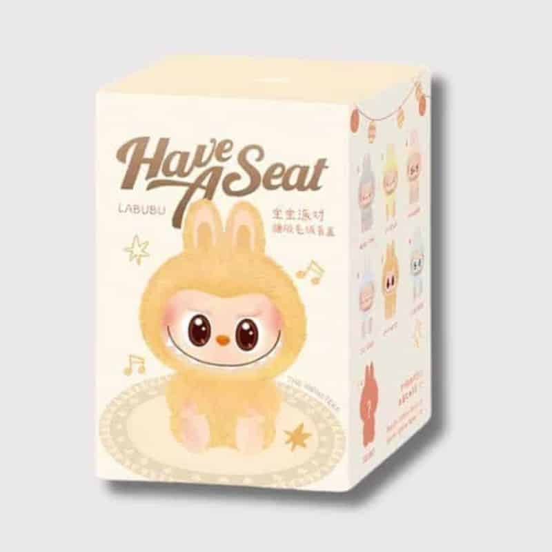 Peluche Labubu Assis en Boîte Mystère, boite jaune contenant peluche labubu mystère